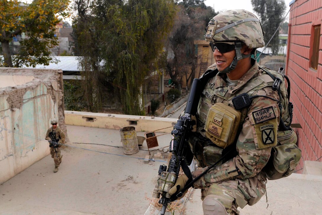 U.S. Army Sgt. Nicholas Mendez provides security atop of the Afghan national police headquarters while U.S. Army Sgt. Juan Perez patrols the perimeter in Jalalabad, Afghanistan, Feb. 3, 2014. Mendez and Perez are assigned to 2nd Battalion, 30th Infantry Regiment.