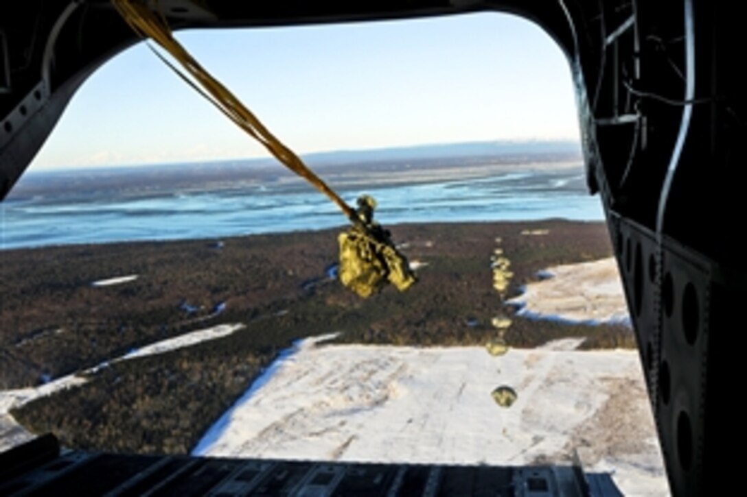 Paratroopers descend from a CH-47 Chinook helicopter over Malamute Drop Zone on Joint Base Elmendorf-Richardson, Alaska, Jan. 29, 2014.  