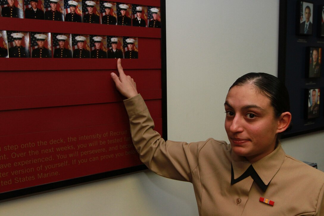 Pvt. Bianca Saunders, a 23-year-old native of Wolcott, Conn., points to her photo on the transformation board inside Recruiting Substation Waterbury, Recruiting Station Springfield, Jan., 10. Saunders graduated recruit training Dec 20, 2013, despite her short height and low body weight. (U.S. Marine Corps photo by Sgt. Richard Blumenstein).