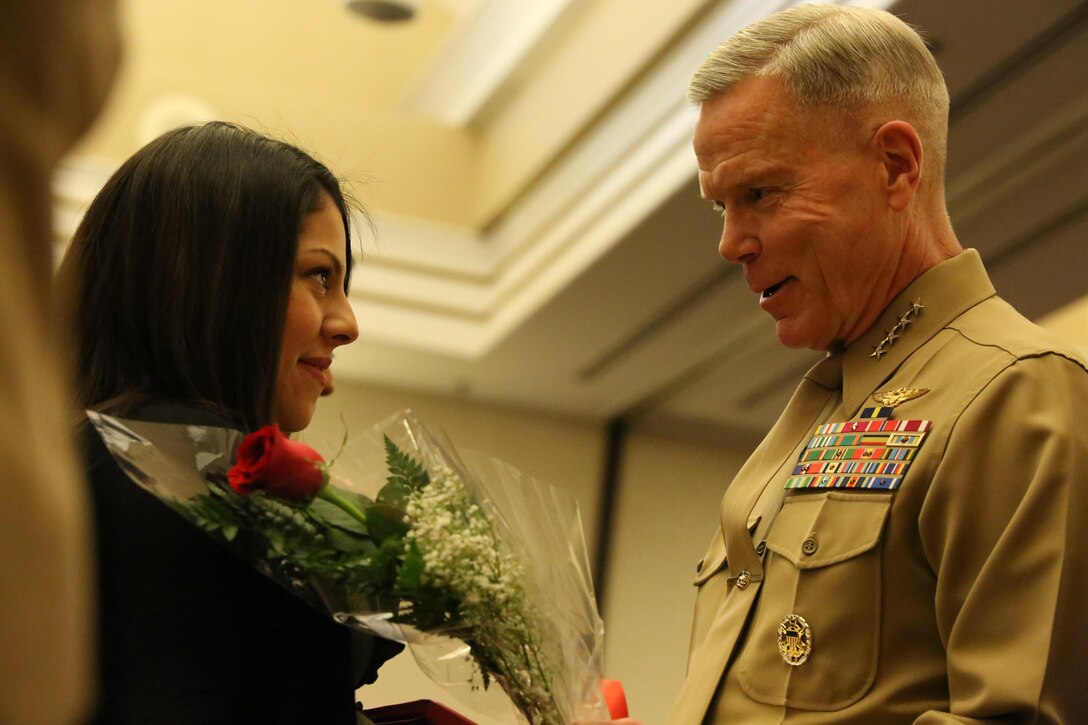 Commandant of the Marine Corps Gen. James Amos presents flowers to Elisse Perez during the Commandant of the Marine Corps Combined Awards Program ceremony where her husband, Gunnery Sgt. Victor Perez, was selected as the Prior Service Recruiter of the Year on Feb. 3, 2014. The wives of the spouses were recognized for the part they play in helping their spouses excel in their jobs as Marines.
