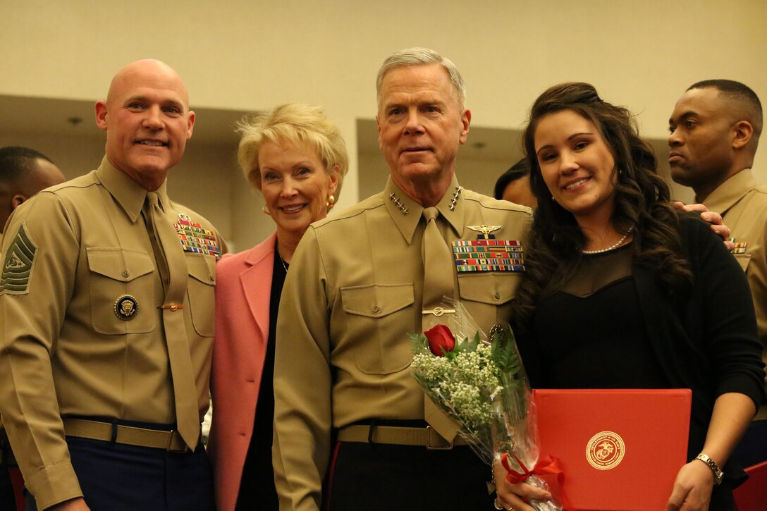 Sergeant Major of the Marine Corps Micheal Barrett, Bonnie Amos and her husband, the Commandant of the Marine Corps Gen. James Amos pose for a photo with Christine Wampler, the wife of Gunnery Sgt. Michael Wampler, during the Commandant of the Marine Corps Combined Awards Program ceremony at The Clubs of Quantico on Feb. 3, 2014. The wives of the spouses were recognized for the part they play in helping their spouses excel.