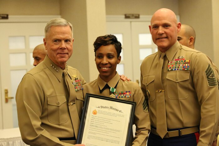 Commandant of the Marine Corps Gen. James Amos and Sgt. Maj. of the Marine Corps Micheal Barrett pose with Sgt. Iasia Brown at The Clubs of Quantico on Feb. 3, 2014. Brown was meritoriously promoted to staff sergeant due to her outstanding performance in 2013. 