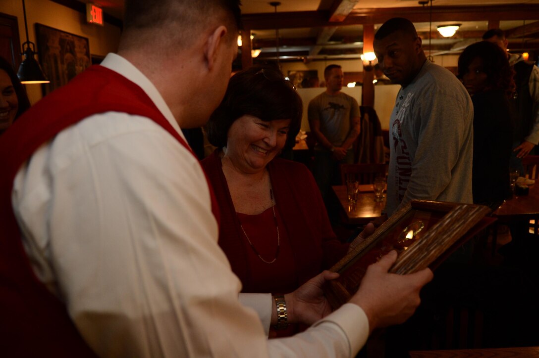 Wilma Vaughn, Marine Corps Base Quantico Community Relations Officer, smiles as she is given a plaque by Maj. Charles O’Neill, inspector-instructor for Delta Co., 4th Light Armored Reconnaissance Battalion at Brock’s Riverside Bar and Grill during the annual Toys for Tots Luncheon on Jan. 28, 2014, for her dedication to the Toys for Tots program. O’Neill explained that Vaughn has consistently been the driving force behind the program for many years.
