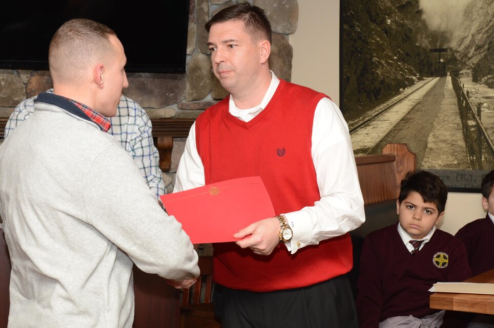Maj. Charles O’Neill, inspector-instructor for Delta Co., 4th Light Armored Reconnaissance Battalion, presents a commanders award to Sgt. Igor Dunayevskiy at Brock’s Riverside Bar and Grill during the annual Toys for Tots Luncheon on Jan. 28, 2014, for his volunteer service during the 2013 Toys for Tots campaign.