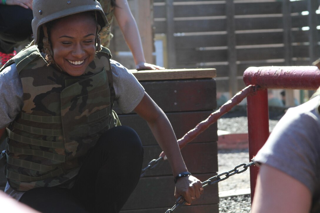 A soccer player from the University of California Riverside attempts to cross a chain bridge during a leadership reaction course aboard Marine Corps Base Camp Pendleton, Feb. 1. Leadership reaction courses are Marine Corps obstacle courses cosisting of 10 stalls that cannot be accomplished without teamwork and strong leadership. The Riverside Officer Selection Officer partnered with UCR and UCSB to have their female soccer players attend the team building event.