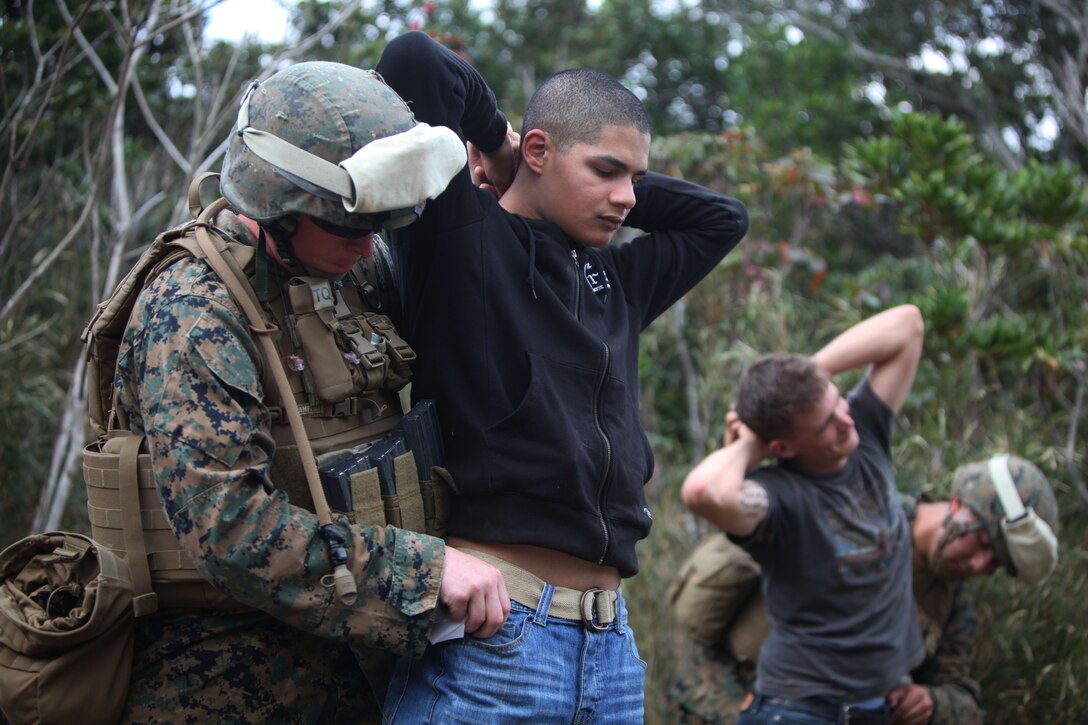 Lance Cpl. Cyle Feathery, a military policeman with Combat Logistics Battalion 31, 31st Marine Expeditionary Unit, and a native of Oswego, Kan, searches a simulated American citizen during a non-combatant evacuation operation exercise at the Jungle Warfare Training Center here Jan 30. The training event involved evacuating simulated American citizens from a foreign nation. This type of mission can be triggered by hostile forces overthrowing a local government, an embassy being overrun, or a natural disaster. The 31st MEU is the Marine Corps’ force in readiness for the Asia-Pacific region and is the only continuously forward-deployed MEU.