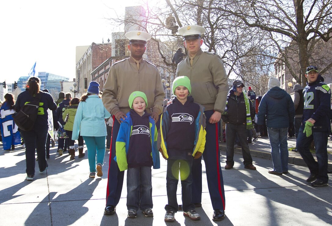 U.S. Marine Cpl. Aaron Pillay (left), supply administration clerk, and Staff Sgt. Zachary Dyer, marketing and public affairs representative, assigned to Marine Corps Recruiting Station Seattle, pose with young Seahawks fans during the Seahawks’ Super Bowl victory parade in Seattle, Wash., Feb. 5, 2014. Approximately 700,000 Seahawks fans gathered in downtown Seattle for the Seahawks’ Super Bowl victory parade. The Seahawks defeated the Denver Broncos 43-8 in Super Bowl XLVIII, Feb. 2. (U.S. Marine Corps photo by Sgt. Reece Lodder)