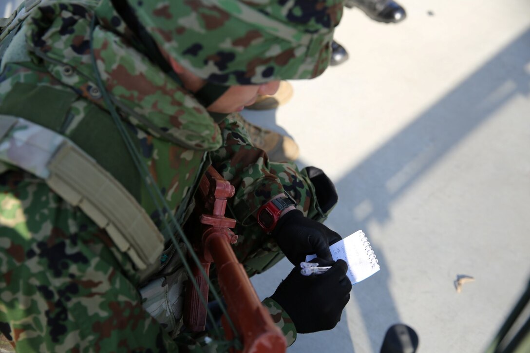 A soldier from the Japan Ground Self-Defense Force takes notes while conducting call-for-fire exercises with 1st Air Naval Gunfire Liaison Company during Exercise Iron Fist 2014 aboard Camp Pendleton, Calif., Feb. 5, 2014. Iron Fist 2014 is an amphibious exercise that brings together Marines and sailors from the 15th Marine Expeditionary Unit, other I Marine Expeditionary Force units, and soldiers from the JGSDF, to promote military interoperability and hone individual and small-unit skills through challenging, complex and realistic training. (U.S. Marine Corps photo by Lance Cpl. Anna K. Albrecht/Released)
