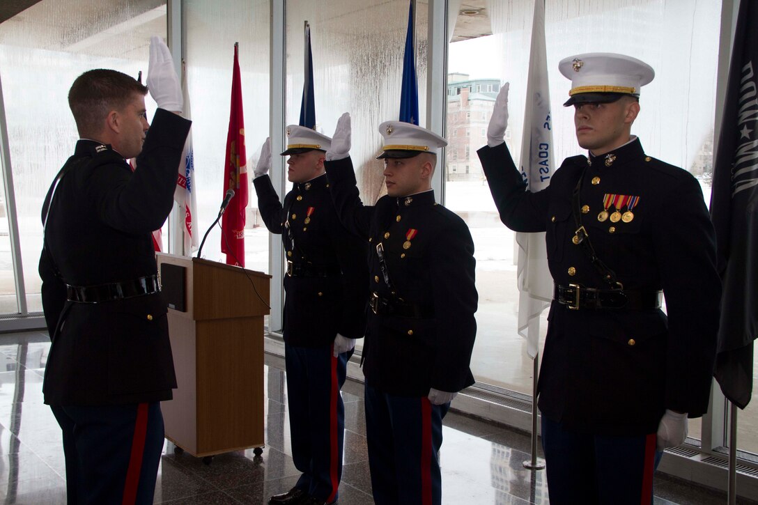 Capt. Chad Luebke administers the Oath of Office to newly commissioned Second Lieutenants Justin Hillebrand, Najieb Mahmoud and Kyle Davis at the Milwaukee County War Memorial Center, Jan. 24, 2014.