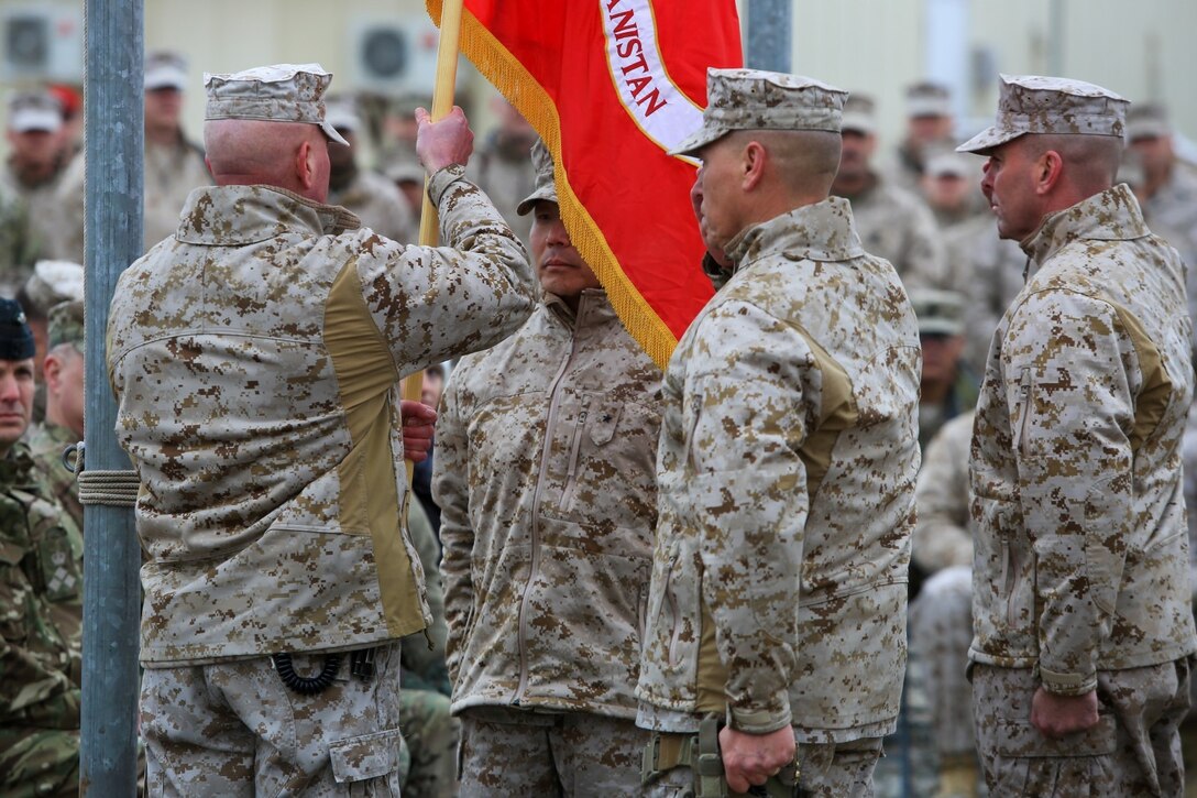 U.S. Marine Corps Maj. Gen. W. Lee Miller, Jr., left, Commanding General of the II Marine Expeditionary Force (MEF) Forward passes the Regional Command Southwest colors to B. Gen. Daniel D. Yoo, Commanding General of Marine Expeditionary Brigade Afghanistan (MEB-A), as part of a Transfer of Authority ceremony on Camp Leatherneck, Helmand province, Afghanistan, Feb. 5, 2014. MEB-A officially relieved II MEF (FWD) and took over their responsibilities for Regional Command (Southwest). (Official Marine Corps Photo by Lance Cpl. Darien J. Bjorndal/Released)
