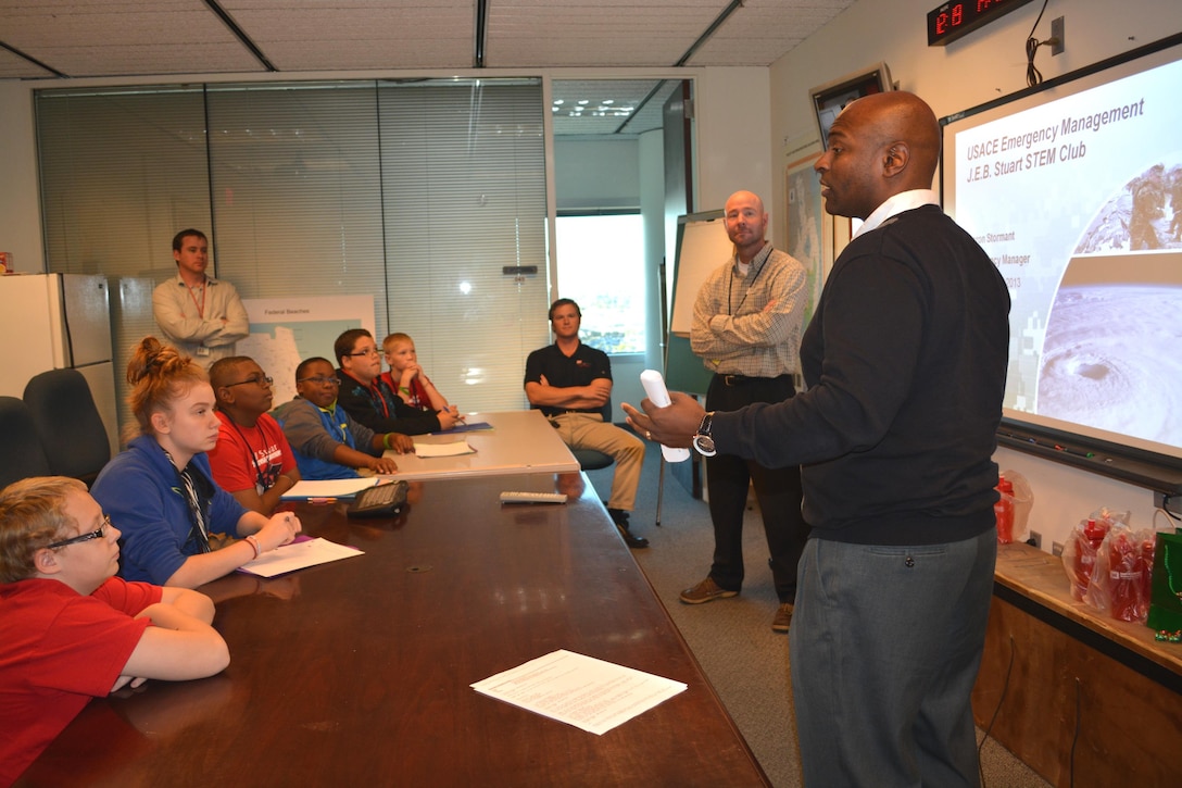 Programs and Project Management Division’s Tim Brown (right) welcomes students from JEB Stuart Middle School’s First Lego® League program and introduces them to Aaron Stormant (second from right), emergency management specialist.