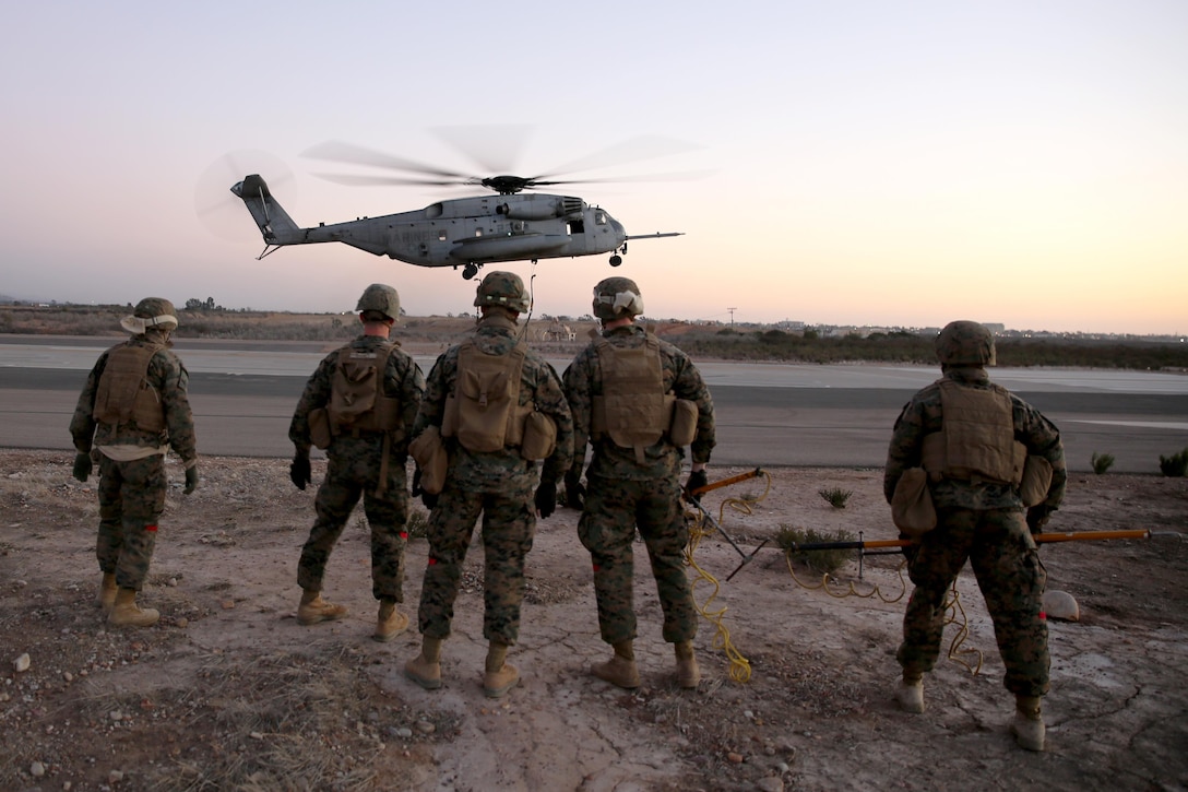 Marines with Combat Logistics Battalion (CLB) 11 wait to disconnect simulated cargo from a CH-53E Super Stallion with Marine Medium Tilitrotor Squadron (VMM) 163 during Helicopter Support Team (HST) training aboard Marine Corps Air Station Miramar, Calif., Feb. 5. Marines with CBL-11 connected and disconnected simulated cargo from the Super Stallion to become more effective in the field.  