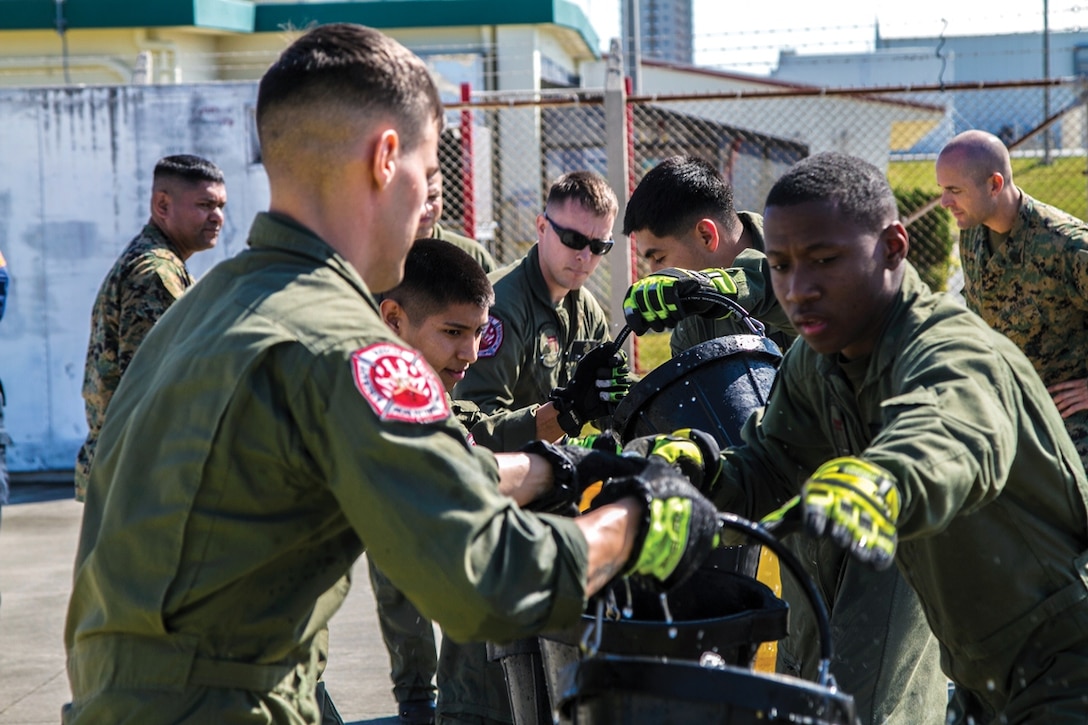 Marines pass buckets of water during the bucket brigade event Jan. 31 at Marine Corps Air Station Futenma. The bucket brigade represents how firefighters fought fires before the advent of technology such as the hand-pumped fire engine. The Marines are with H&HS, MCAS Futenma, MCB Camp Butler, MCIPAC. 