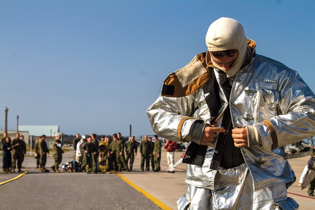 Airman 1st Class Nathaniel Tieden dons his protective clothing during a firefighter rodeo Jan. 31 at Marine Corps Air Station Futenma. Each of the various exercises during the firefighter rodeo style event tested the skills of the contestants in multiple aspects of their daily tasks. Tieden is a fire protection specialist with Fire Protection Flight, 18th Civil Engineering Squadron, Civil Engineering Group, 18th Wing, currently assigned to Headquarters and Headquarters  Squadron, MCAS Futenma, Marine Corps Base Camp Smedley D. Butler, Marine Corps Installations Pacific. 