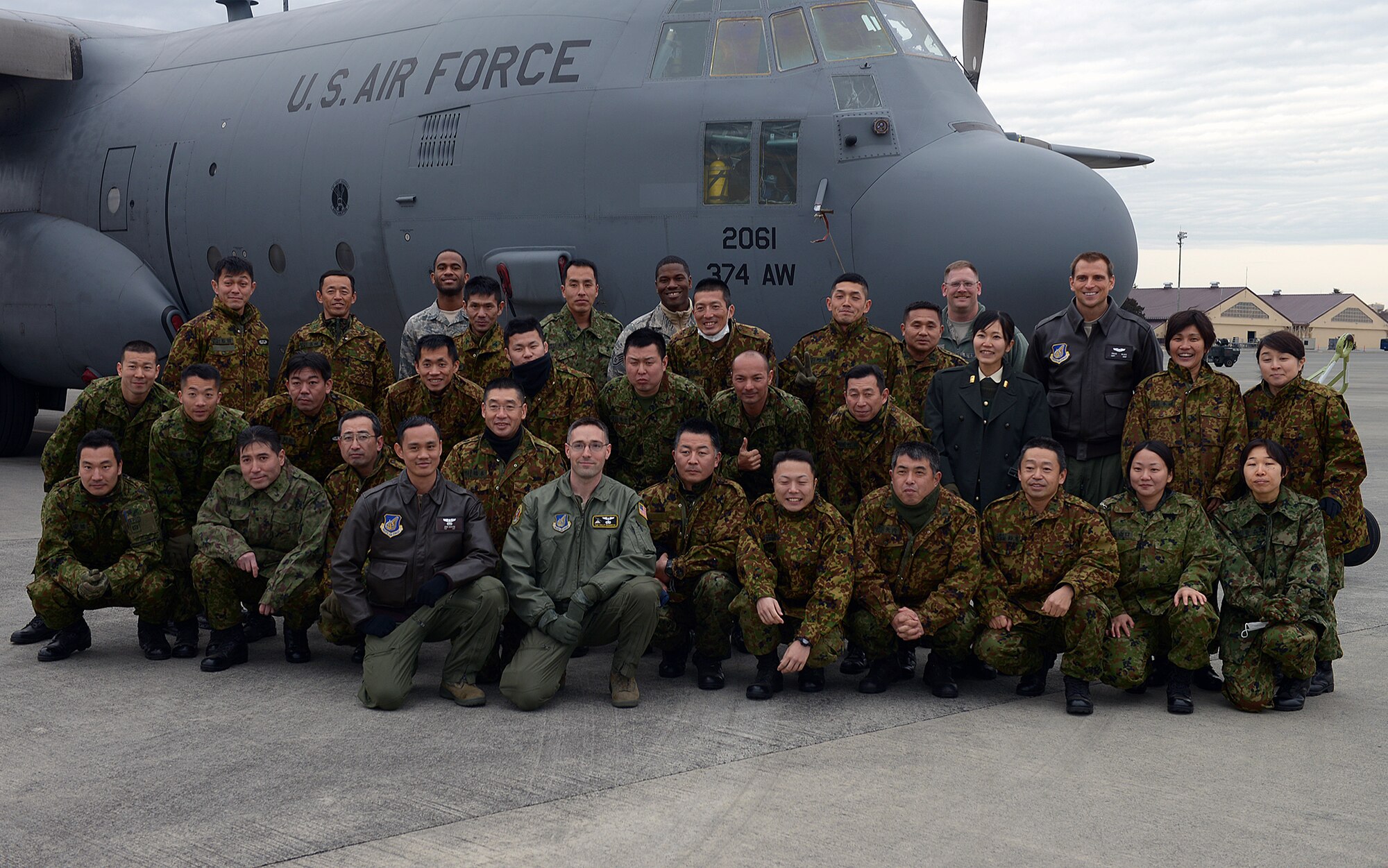 Members of the Japan Ground Self-Defense Force pose for a photo with Yokota Airmen in front of a C-130 Hercules at Yokota Air Base, Japan, Feb. 6, 2014. The C-130 display capped off a day-long bilateral event between the JGSDF and the 374th Security Forces Squadron. (U.S. Air Force photo by Airman 1st Class David Danford/Released)