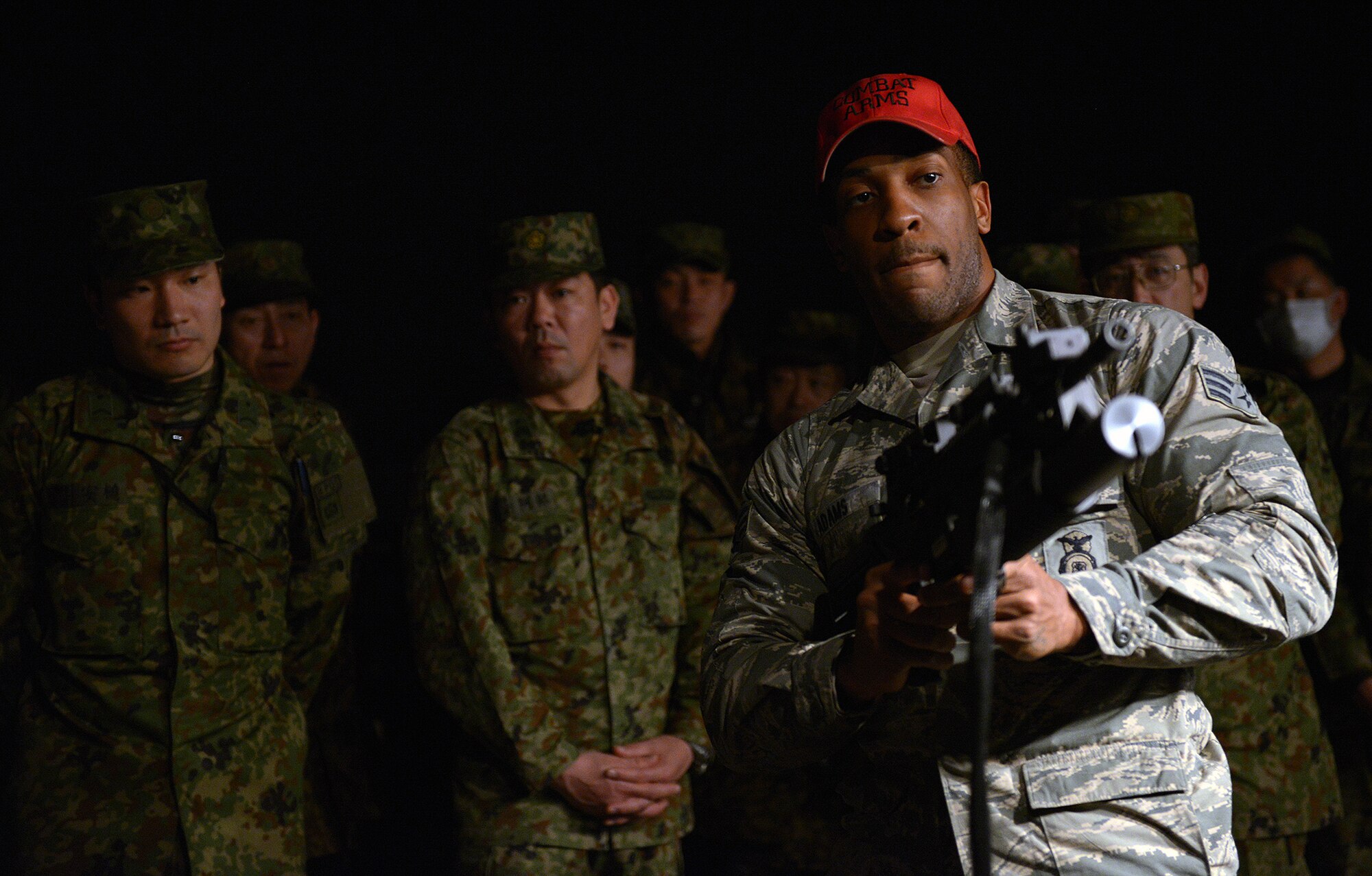 Senior Airman Dominique Adams, 374th Security Forces Squadron combat arms instructor, teaches Japan Ground Self-Defense Force members how to use the weapons in the combat arms training simulator at Yokota Air Base, Japan, Feb. 6, 2014. A total of 30 JGSDF members from 1st Division Headquarters Unit took part in the tour. (U.S. Air Force photo by Airman 1st Class David Danford/Released)