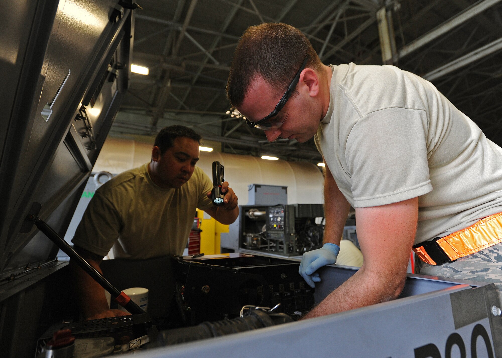 Senior Airman Joshua Braun, 15th Maintenance Squadron aerospace ground equipment journeyman, right, performs routine maintenance on a low pressure air compressor as Tech. Sgt. Kekoa Uyeda, 154th Maintenance Squadron AGE craftsman, left, inspects the process at the KC-135 AGE shop at Joint Base Pearl Harbor-Hickam, Hawaii, Feb. 6, 2014. (U.S. Air Force photo/Master Sgt. Jerome S. Tayborn)