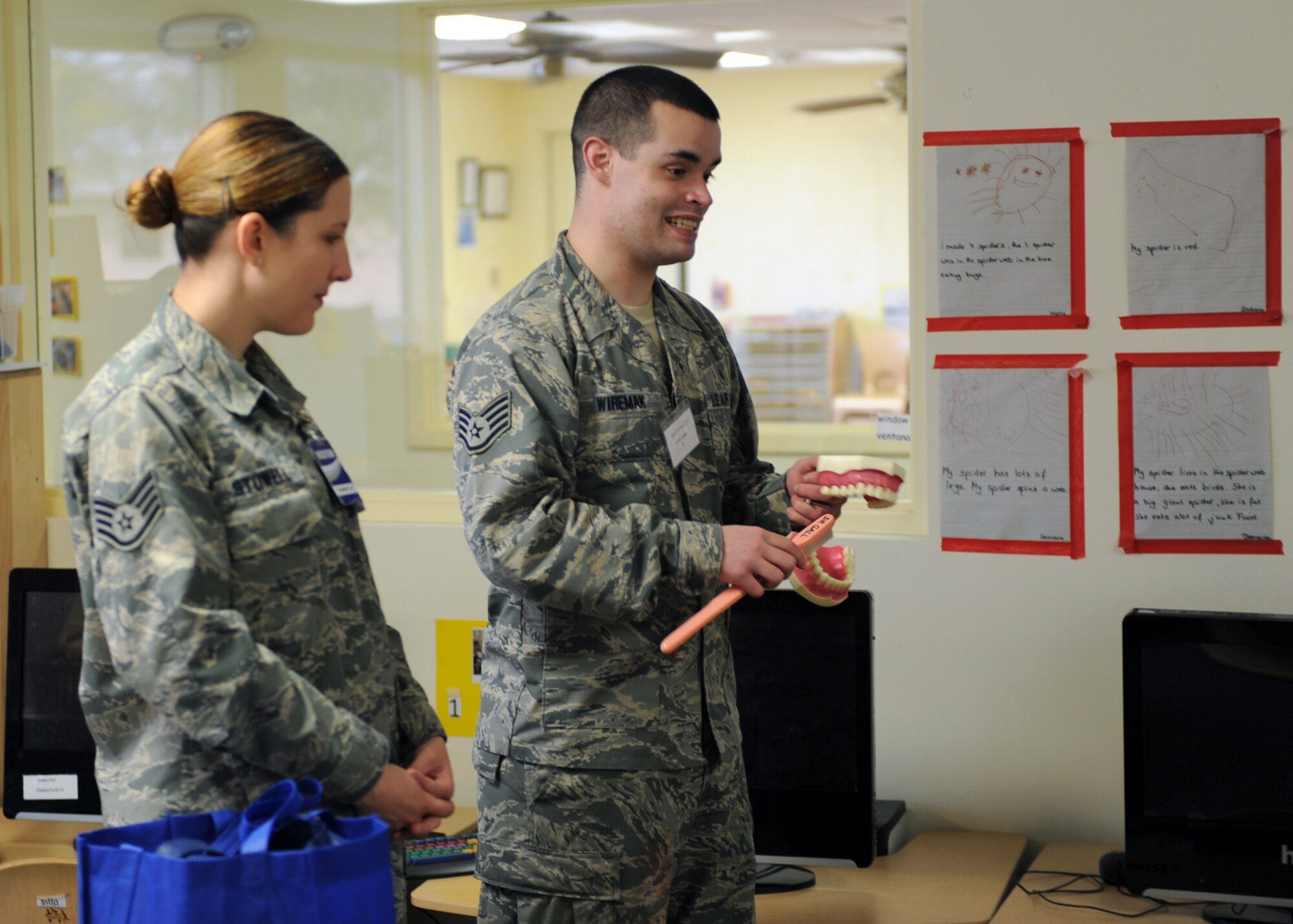 U.S. Air Force Staff Sgt.'s Kristy Stowell and Kyle Wireman, 355th Dental Squadron dental technicians, show children how to properly brush teeth by demonstrating with an oversized toothbrush and set of teeth at the D-M Child Development Center at Davis-Monthan Air Force Base, Ariz., Feb. 3, 2014.  The month of February is National Children's Dental Health Month and each year, the dental squadron reaches out to the D-M community to educate children about proper dental hygiene.  (U.S. Air Force photo by Airman 1st Class Chris Massey)