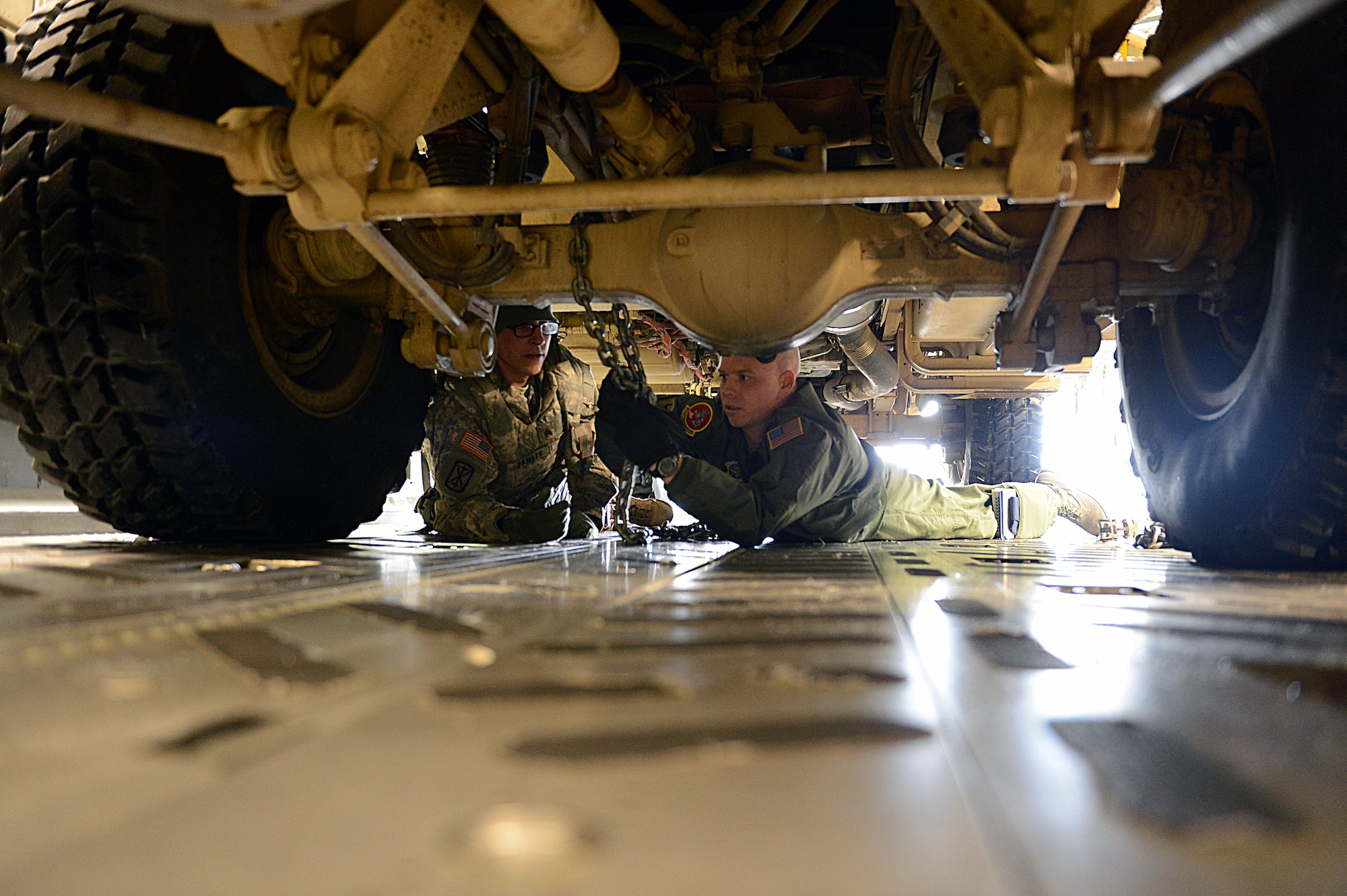 Army Sgt. Robert Pember, Alpha Battery, 5th battalion, HIMARS, 3rd Field Artillery Regiment, 17th Fires Brigade recon sergeant, and Master Sgt. Paul Thompson, 10th Airlift Squadron loadmaster, chain down an M142 High Mobility Artillery Rocket System Feb. 1, 2014 at Joint Base Lewis-McChord, Wash. The weeklong HI-RAIN exercise’s planning began months prior and consisted of numerous joint concept briefs to coordinate and plan the exercise’s timeline. (U.S. Air Force photo/ Airman 1st Class Jacob Jimenez)