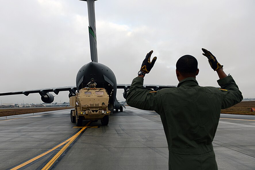 Staff Sgt. Liam McPhail, 10th Airlift Squadron loadmaster, guides a M142 High Mobility Artillery Rocket System’s crew onto a C-17 Globemaster III aircraft during a HIMARS Rapid Infiltration exercise Feb. 1, 2014 at Joint Base Lewis-McChord, Wash. More than 100 active duty and reserve Airmen and soldiers participated in the exercise, flying six missions from McChord Field to Schoonover, Calif. (U.S. Air Force photo/ Airman 1st Class Jacob Jimenez)
