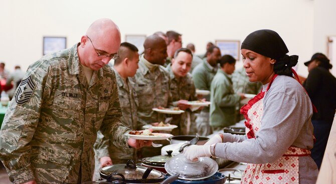 Chief Master Sgt. Alexander Del Valle, 366th Fighter Wing command chief, chooses from a wide array of foods presented at the Soul Food Taste Fest at Mountain Home Air Force Base, Idaho, Feb. 5, 2014. Much of preparations of soul food is guided on personal tastes and by remembering simple recipes that have been handed down from generation to generation. (U.S. Air Force photo by Airman 1st Class Malissa Lott/RELEASED)