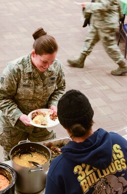 Staff Sgt. Ashelie Gross, 366th Security Forces Squadron police services confinement NCO in-charge, receives servings of the many foods available at the Soul Food Taste Fest at Mountain Home Air Force Base, Idaho, Feb. 5. 2014. Like Gross, many Airmen stopped by to enjoy a cultural meal that dates back to the Civil War era. (U.S. Air Force photo by Airman 1st Class Malissa Lott/RELEASED)
