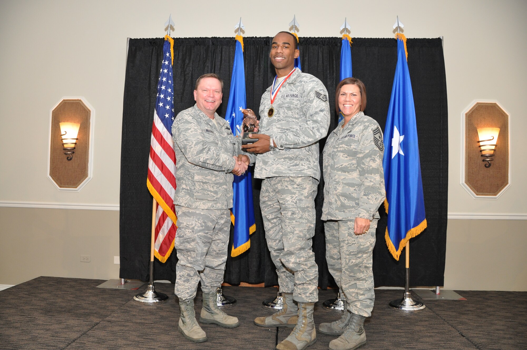 Brig. Gen. Samuel Mahaney, Air Reserve Personnel Center commander, and Chief Master Sgt. Ruthe Flores, ARPC command chief, present the ARPC Physical Training Leader of the Year award to Staff Sgt. Sean Cooper. Mahaney honored ARPC’s 2013 outstanding performers of the year as well as their A1 annual award winners at the Summit Conference and Event Center Feb. 6, 2014, in Denver. (U.S. Air Force photo/Tech. Sgt. Rob Hazelett)