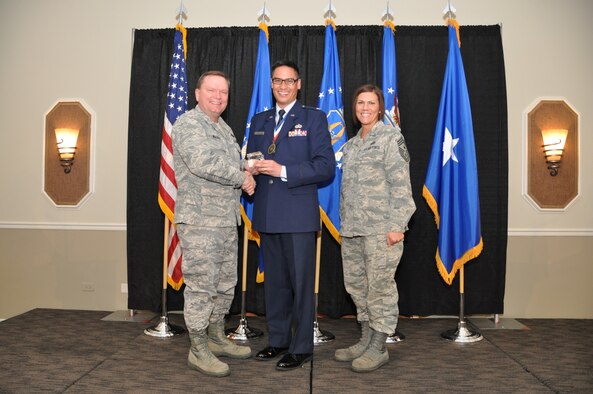 Brig. Gen. Samuel Mahaney, Air Reserve Personnel Center commander, and Chief Master Sgt. Ruthe Flores, ARPC command chief, present the Gen. Horace M. Wade Innovation Award to Lt. Col. Michael Ortiz. Mahaney honored ARPC’s 2013 outstanding performers of the year as well as their A1 annual award winners at the Summit Conference and Event Center Feb. 6, 2014, in Denver. (U.S. Air Force photo/Tech. Sgt. Rob Hazelett)