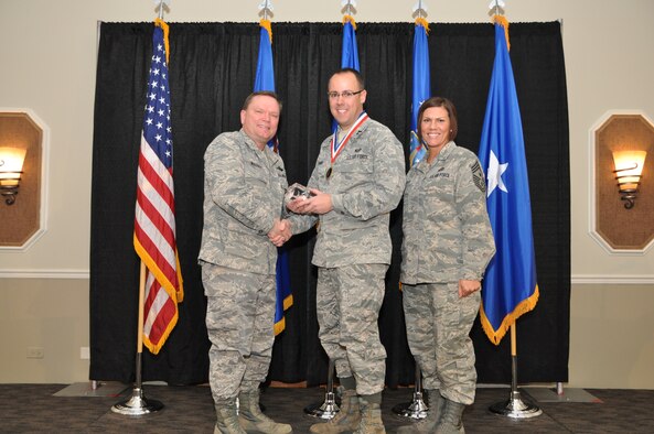 Brig. Gen. Samuel Mahaney, Air Reserve Personnel Center commander, and Chief Master Sgt. Ruthe Flores, ARPC command chief, present the Personnel Reserve Company Grade Officer of the Year award to Capt. Andrew Williams. Mahaney honored ARPC’s 2013 outstanding performers of the year as well as their A1 annual award winners at the Summit Conference and Event Center Feb. 6, 2014, in Denver. (U.S. Air Force photo/Tech. Sgt. Rob Hazelett)