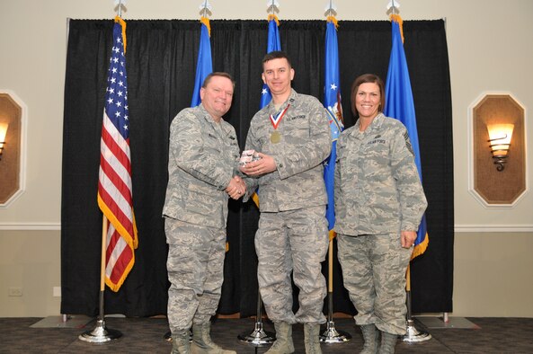 Brig. Gen. Samuel Mahaney, Air Reserve Personnel Center commander, and Chief Master Sgt. Ruthe Flores, ARPC command chief, present the Personnel Company Grade Officer of the Year award to Capt. Adam Ertsey. Mahaney honored ARPC’s 2013 outstanding performers of the year as well as their A1 annual award winners at the Summit Conference and Event Center Feb. 6, 2014, in Denver. (U.S. Air Force photo/Tech. Sgt. Rob Hazelett)