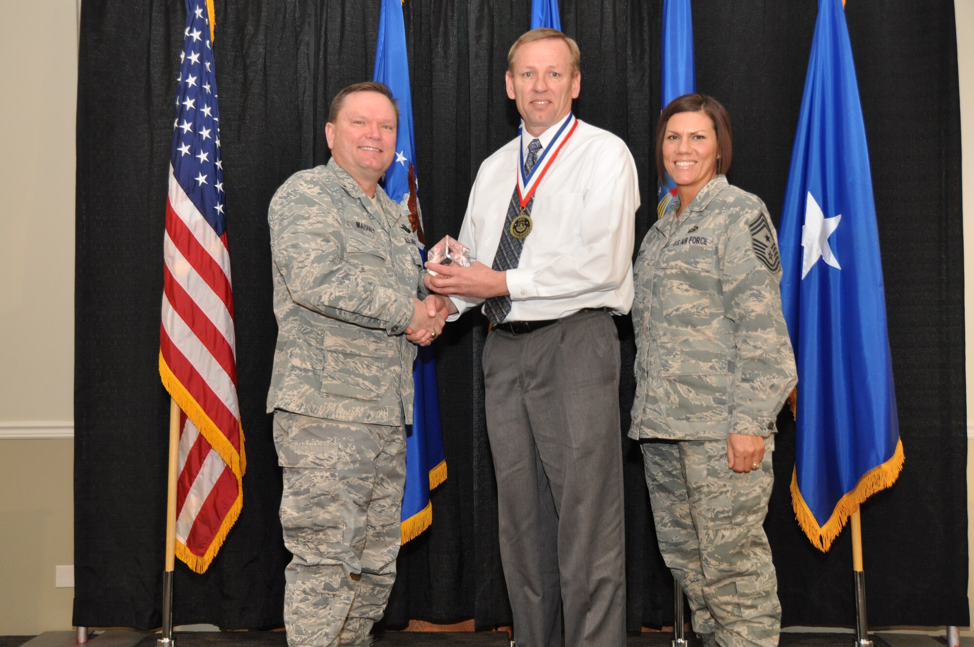 Brig. Gen. Samuel Mahaney, Air Reserve Personnel Center commander, and Chief Master Sgt. Ruthe Flores, ARPC command chief, present the Civilian Specialist of the Year award to Stephen Willoughby. Mahaney honored ARPC’s 2013 outstanding performers of the year as well as their A1 annual award winners at the Summit Conference and Event Center Feb. 6, 2014, in Denver. (U.S. Air Force photo/Tech. Sgt. Rob Hazelett)