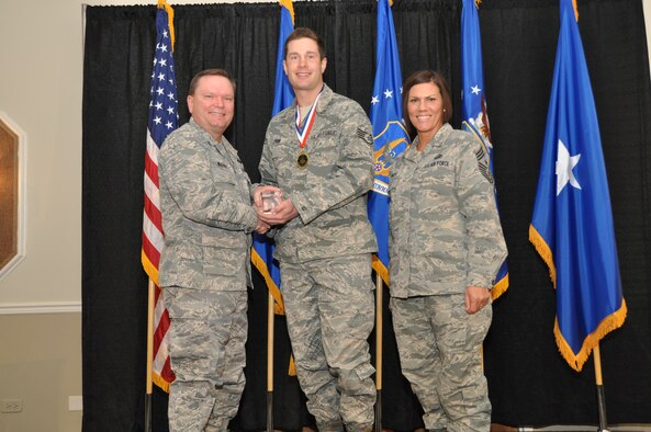 Brig. Gen. Samuel Mahaney, Air Reserve Personnel Center commander, and Chief Master Sgt. Ruthe Flores, ARPC command chief, present the Force Support NCO of the Year, Air Reserve Component award to Staff Sgt. Matthew Faini. Mahaney honored ARPC’s 2013 outstanding performers of the year as well as their A1 annual award winners at the Summit Conference and Event Center Feb. 6, 2014, in Denver. (U.S. Air Force photo/Tech. Sgt. Rob Hazelett)