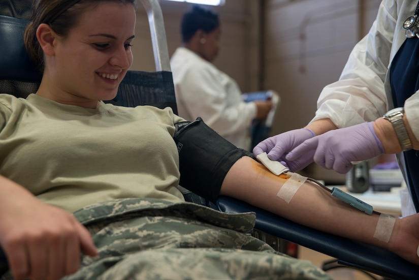 Senior Airman Melissa Goslin, 1st Combat Camera photojournalist, donates blood during the American Red Cross blood drive Feb. 5, 2014, at Joint Base Charleston - Air Base, S.C. The donated blood will be sent to a Red Cross blood component laboratory where it will be processed into several components; red blood cells, plasma, platelets and/or cryoprecipitate. A single blood donation may help up to three different people. (U.S. Air Force photo/Senior Airman Ashlee Galloway)