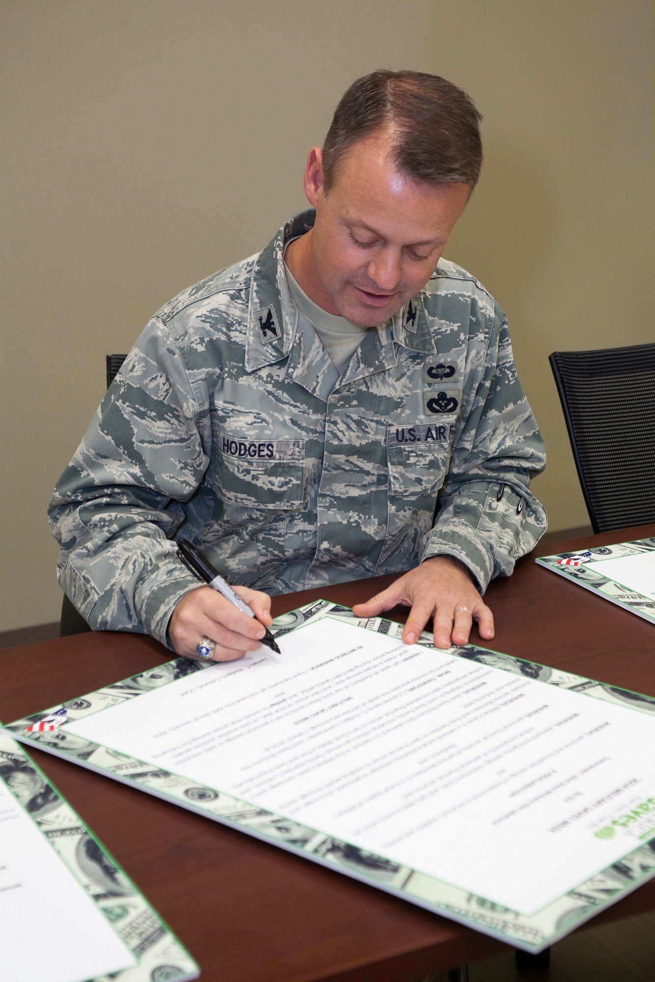 Col. James Hodges, Joint Base McGuire-Dix-Lakehurst and 87th Air Base Wing commander, signs the Military Saves Proclamation at the beginning of Military Save Month, Jan. 29, 2014 at JB MDL, N.J. The Military and Family Support Center hosts several events throughout February in honor of this year’s Military Saves Campaign. (U.S. Air Force photo/Wayne Russell)