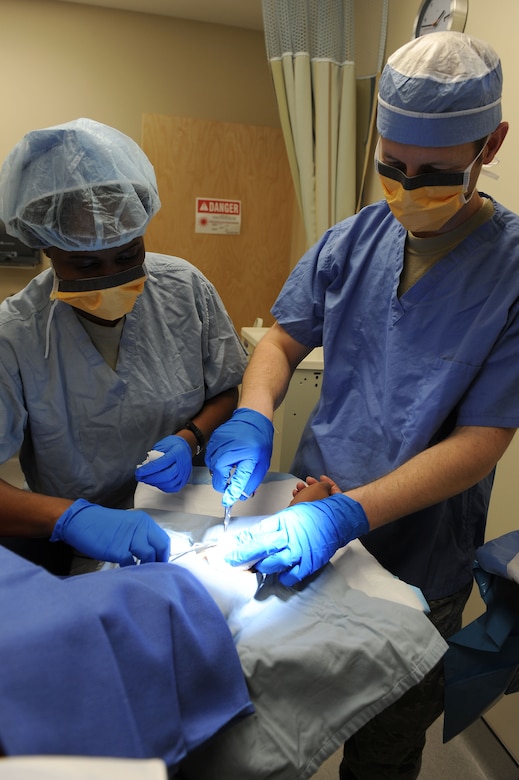 From left, U.S. Air Force Staff Sgt. ChaLita Tillman, 633rd Medical Operations Squadron medical technician, and U.S. Air Force Maj. Jason Boyd, 633rd Medical Operations Squadron chief of dermatology, perform a surgery at Langley Air Force Base, Va., Feb. 4, 2014. Meeting the growing medical needs for military members, the Dermatology clinic specializes in treating conditions involving hair, skin, and nails. Tillman hails from Washington, D.C. and Boyd is a native to Tacoma, Texas. (U.S. Air Force photo by Senior Airman Brittany Paerschke-O’Brien/Released)