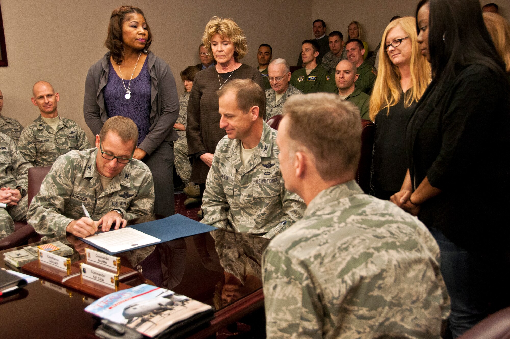 Col. Corey Martin, 60th Air Mobility Wing commander, Col. Matthew Burger, 349th Air Mobility Wing commander, and Col. Martin Chaping, 621st Contingency Response Wing commander, sign the proclomation against teen dating violence Wednesday. (U.S. Air Force photo/Senior Airman Madelyn Brown)