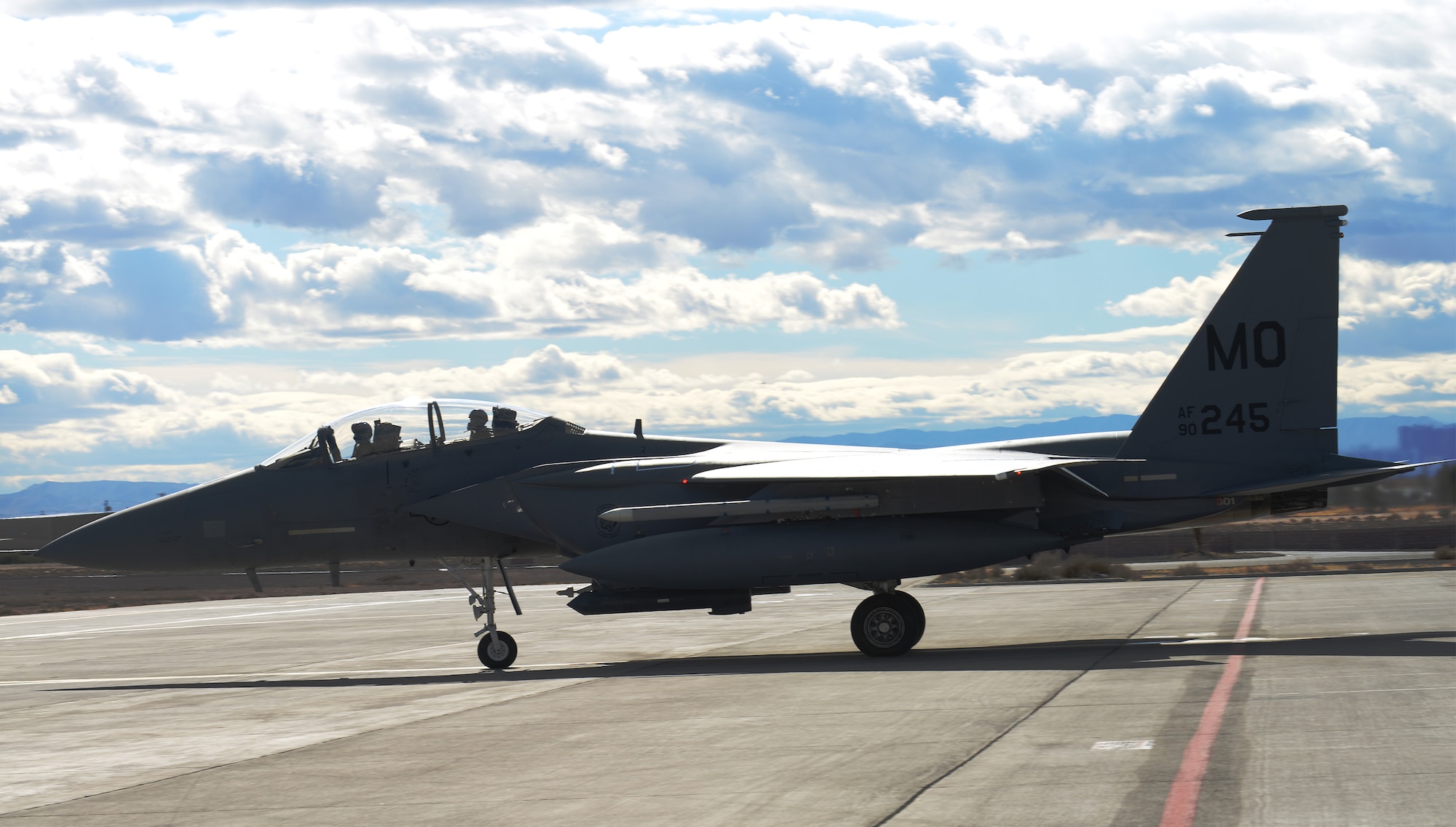 Col. Chris Short, 366th Fighter Wing commander, and Capt. Bernard Froehlich, 391st Fighter Squadron weapon systems officer, both from Mountain Home Air Force Base, Idaho, cross the solid red line on the flight line at Nellis Air Force Base, Nev. Air force units from the around the country and the world have come to Nellis AFB to work together on simulated combat scenarios to prepare them for future real-world conflicts or war. (U.S. Air Force photo by Senior Airman Benjamin Sutton/Released)