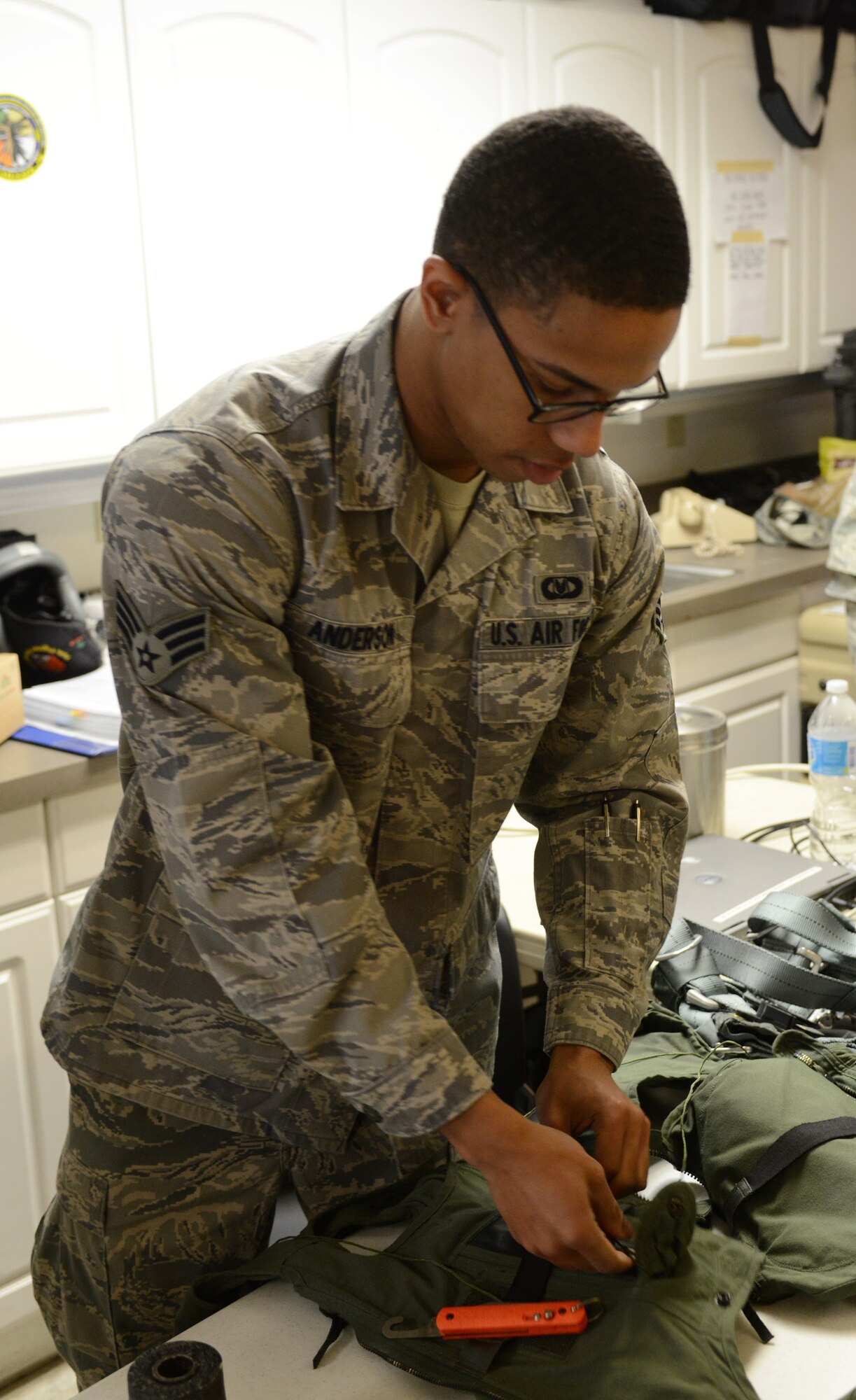 Senior Airman Albert Anderson, 366th Operation Support Squadron aircrew flight equipment technician, from Mountain Home Air Force Base, Idaho, inspects the flight equipment of an F-15E Strike Eagle aircrew member before a sortie Feb. 3, 2014, at Nellis Air Force Base, Nev. Anderson is among more than 3,200 service members participating in the Red Flag 14-1. Red Flag is the U.S. Air Force’s premier exercise and gives air and ground crews the opportunity to experience realistic, stressful combat situations in a controlled environment to increase their ability to complete missions and return home. (U.S. Air Force photo by Senior Airman Benjamin Sutton/Released)