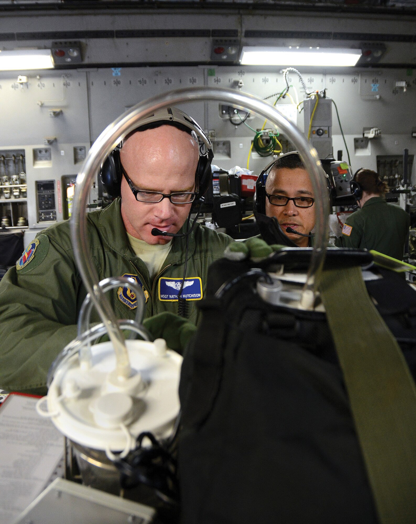 WRIGHT-PATTERSON AIR FORCE BASE, Ohio - Master Sgt. Nathan Hutchison, left, and Maj. Romeo Cabungcal, both assigned to the 445th Aeromedical Evacuation Squadron, set up their equipment onboard a C-17 Globemaster III before departing for an AES training mission Jan. 11, 2014. Two crews of five people each flew the tandem training mission. Each crew consists of two nurses and three medical technicians. The flyers are required to fly in a crew position at least once every 90 days to stay qualified. (U.S. Air Force photo/ Tech. Sgt. Frank Oliver)