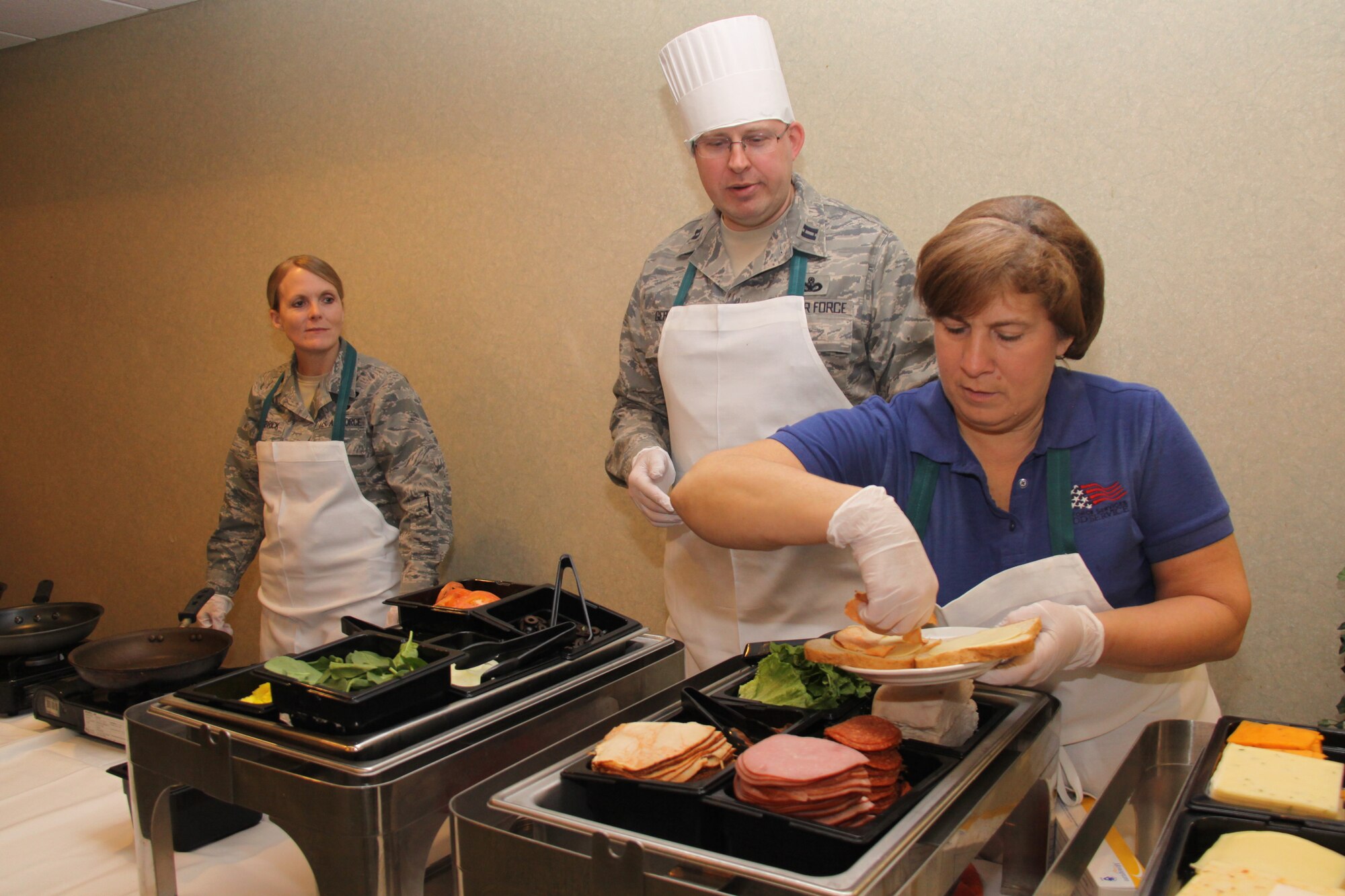 Col. Stacey L.  Scarisbrick, 911th Mission Support Group commander; Capt. Randall P. Gernhardt, 911th Security Forces Squadron commander; and Mrs. Lynn Charles, Club Cargo Bay kitchen manager,  prepare gourmet grilled cheese sandwiches for lunch at the club here at the Pittsburgh International Airport Air Reserve Station, Feb. 4, 2014. Scarisbrick and Gernhardt were the guest chefs for the event.  Club Cargo Bay will be offering the gourmet grilled cheese every first Tuesday of the month and a pasta bar every second Tuesday of the month from 11 a.m. to 1 p.m.  Guest chefs scheduled for Feb. 11 are Maj. Frank A. Mercurio, 911th Airlift Wing executive officer and Maj. Richard D. Frye, 911th Force Support Squadron – Services operations officer.  (U.S. Air Force photo by Master Sergeant Mark A. Winklosky)