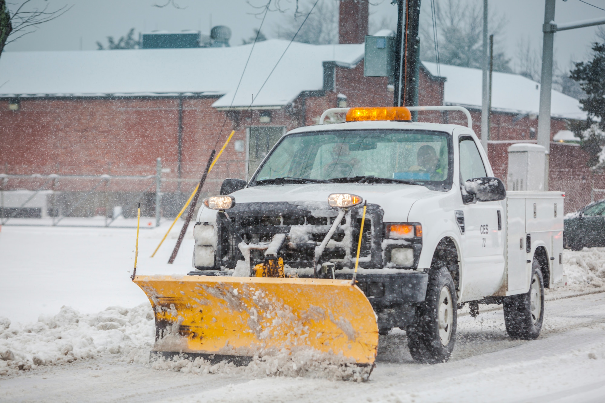 The 87th Civil Engineer Squadron's snow control team plows and salts the roads during a snowstorm to return to an operationally safe status Feb. 3, 2014, at Joint Base McGuire-Dix-Lakehurst, N.J. As soon as there is a report of a snow storm, the base implements the process of clearing the runways and aircraft parking ramps, all the roads and parking lots to return the base to normal operations. (U.S. Air Force photo by Wayne Russell/Released)