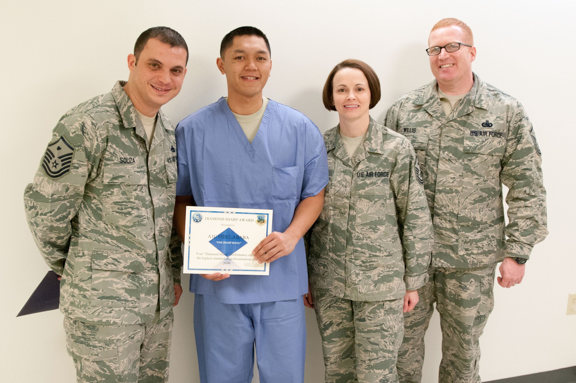 Hanscom first sergeants present Airman 1st Class Fidel Ababa the first Diamond Sharp Award at the 66th Medical Squadron Dental Clinic Jan. 23. (left to right) Master Sgt. Nicholas Souza, Master Sgt. Pattie Hassan and Master Sgt. Stephen Willis and other first sergeants named Ababa the first recipient of the award for performance reflecting the highest standard of professionalism and pride. (U.S. Air Force photo by Mark Wyatt)