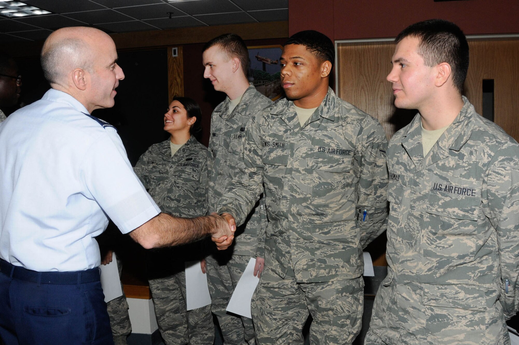 Colonel Lester A. Weilacher, 66th Air Base Group commander, congratulates Airman Timothy Lewis-Smith upon his completion of the First Term Airman Class in the Brown Building, Jan. 31 The week-long course teaches first-term Airmen at Hanscom about the many base resources available to help them have a successful Air Force career. Airmen attend the class within the first 60 days upon arriving to their first duty section. (U.S. Air Force photo by Linda LaBonte Britt)