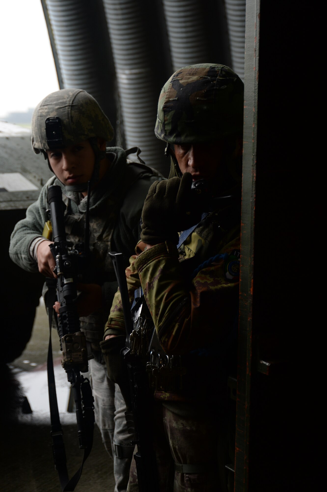 A U.S. Air Force Airman assigned to 704th Munitions Support Squadron and an Italian Air Force Airman assigned to 6th STORMO survey a building before entering during a joint training exercise at Ghedi Air Base, Italy, Jan. 31, 2014. Both air forces conducted the training to better suit each air force's response patterns with the others'.   (U.S. Air Force photo by Staff Sgt. Joe W. McFadden / Released)