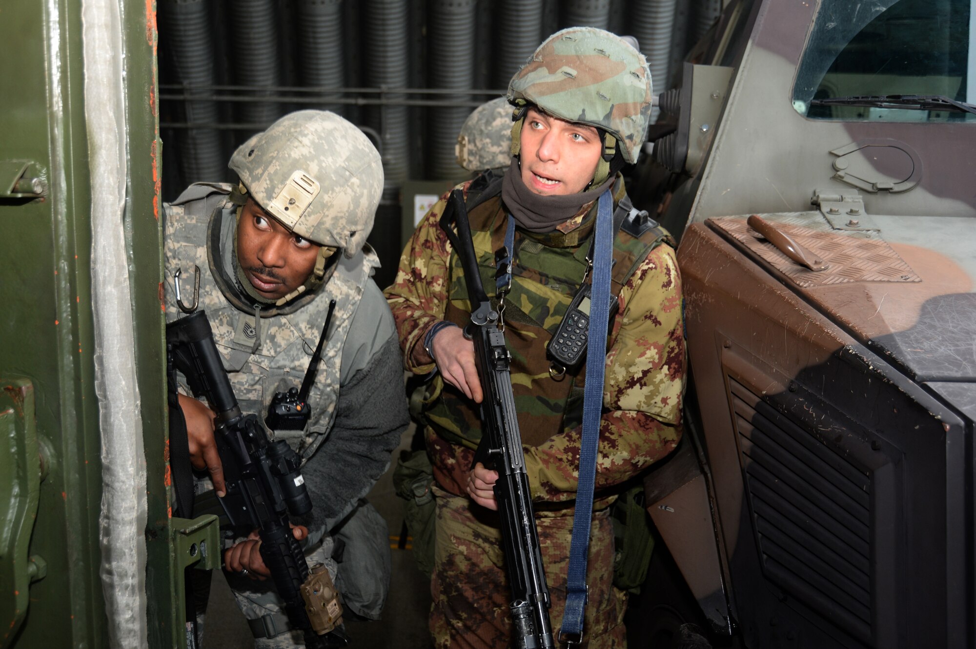 A U.S. Air Force Airman assigned to 704th Munitions Support Squadron and an Italian Air Force Airman assigned to 6th STORMO await instructions during a joint training exercise at Ghedi Air Base, Italy, Jan. 31, 2014. The 704th MUNSS is assigned to Ghedi Air Base which is maintained by the Italian Air Force.   (U.S. Air Force photo by Staff Sgt. Joe W. McFadden / Released)