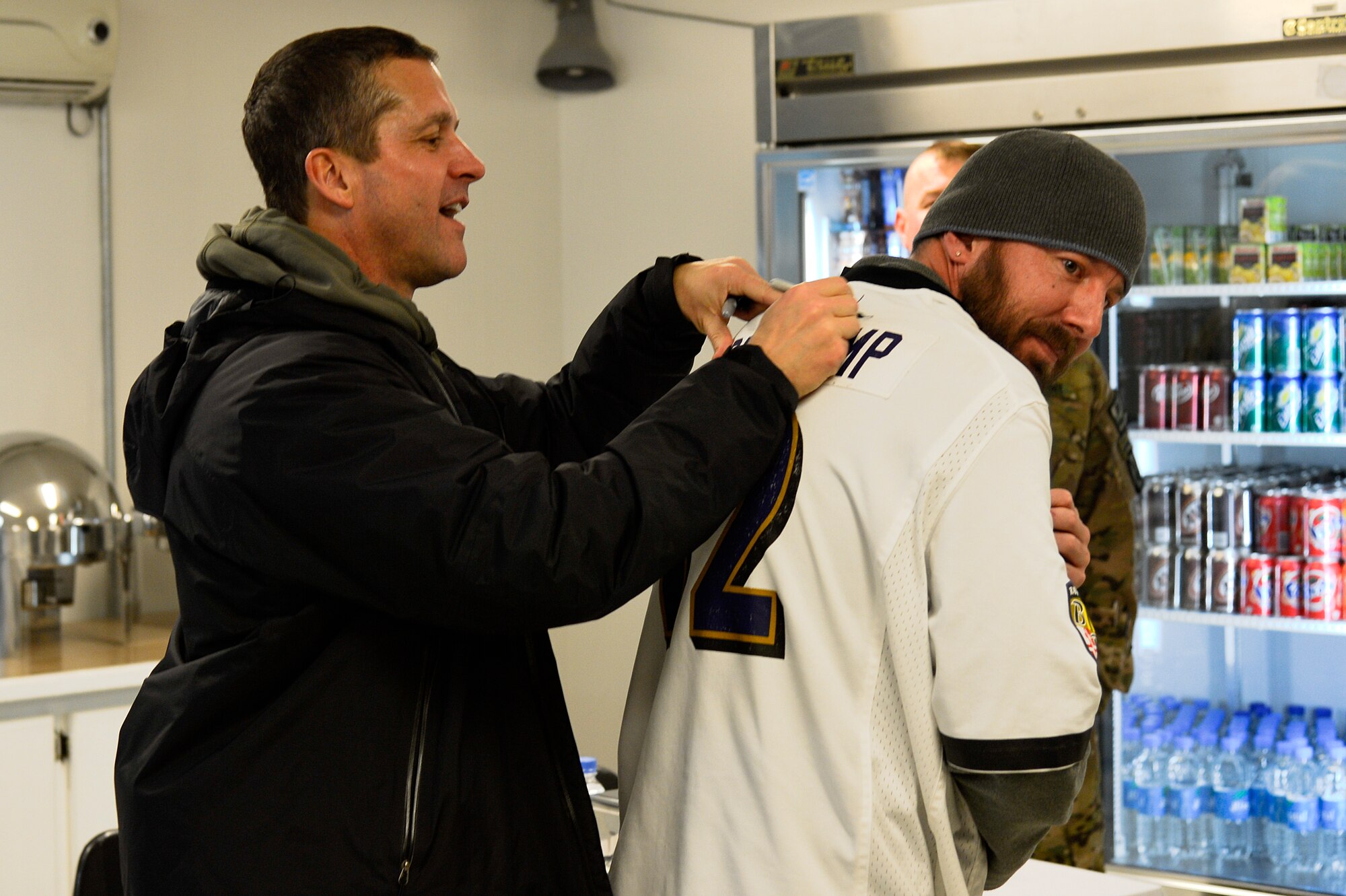 Baltimore Ravens head coach, John Harbaugh, signs a jersey while visiting Service members and civilians at Bagram Airfield, Afghanistan, Feb. 6, 2014. Harbaugh is on a tour through the Middle East with U.S. Army Chief of Staff Gen. Raymond Ordeirno. (U.S. Air Force photo by Senior Airman Kayla Newman/Released)