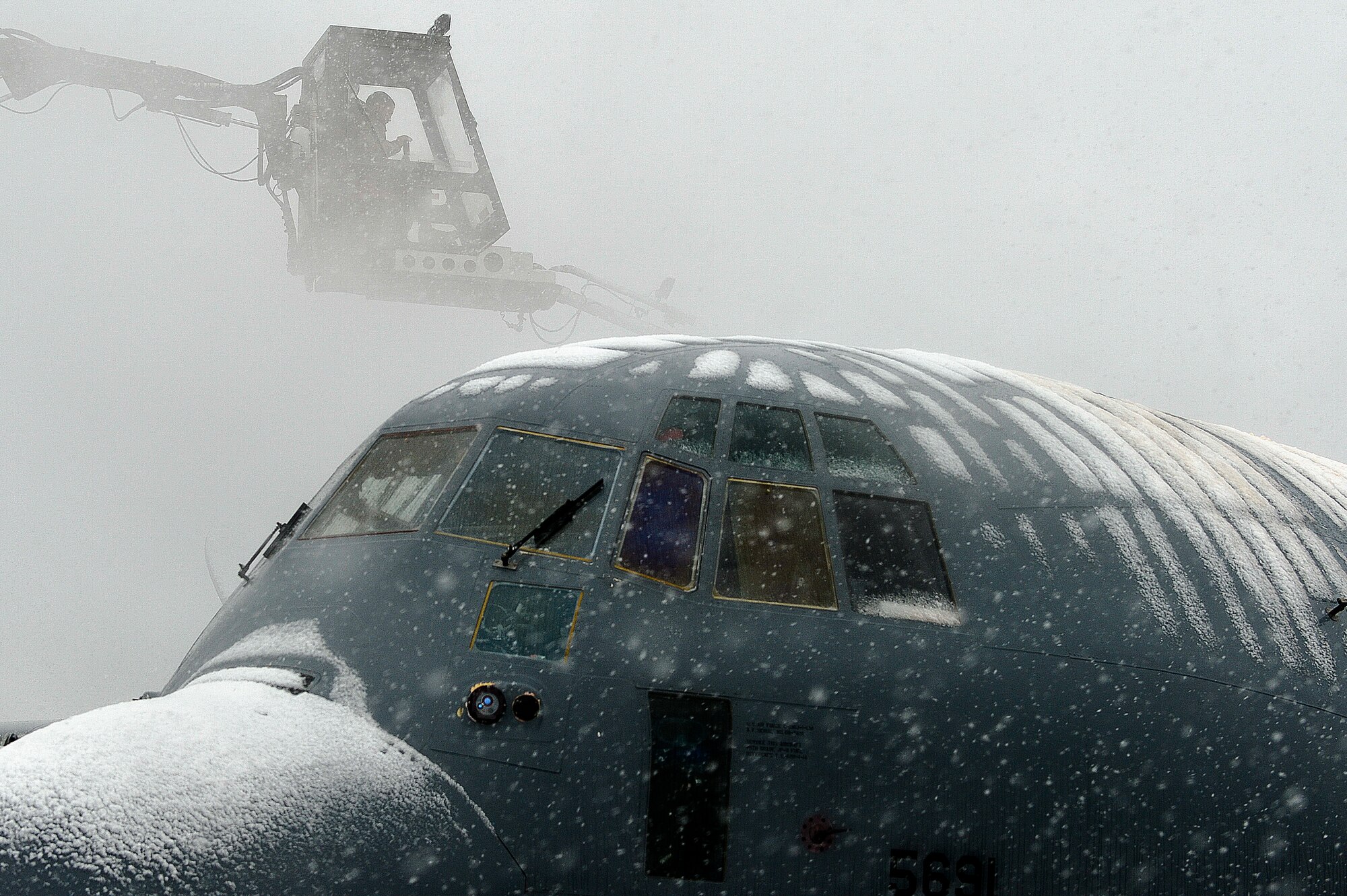 A U.S. Air Force Airman defrosts a C-130J Super Hercules at Bagram Airfield, Afghanistan, Feb. 6, 2014. Snowfall began at approximately 2:30 a.m., with an expected maximum accumulation of four inches. (U.S. Air Force photo by Senior Airman Kayla Newman/Released)