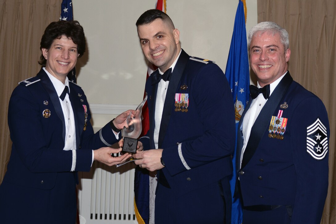 RAF ALCONBURY, United Kingdom - Maj. Kevin Eberhart, 423rd Security Forces Squadron commander, accepts the 501st Combat Support Wing Civilian Volunteer of the Year Award on behalf of Treena Gilbert, 423rd Security Forces Squadron. Gilbert, from Chesterfield, Derbyshire, was the wing project officer for the largest overseas Veteran's Day event, organizing 190 volunteers to host 160 distinguished visitors and 500 other attendees at Madingley American Cemetery. She also led the lunch ticket sales for the Philippines disaster relief drive, raising more than $5,000. (U.S. Air Force photo by Tech. Sgt. Chrissy Best)