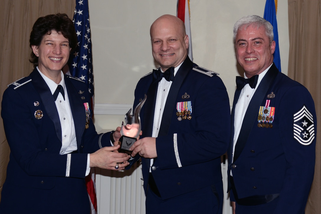 RAF ALCONBURY, United Kingdom - Col. Brian May, 501st Combat Support Wing vice commander, accepts the 501st Combat Support Wing Company Grade Officer of the Year Award on behalf of Capt. Courtney Hemmert, 501st CSW Staff. Hemmert designed a sexual assault response exercise concept that was used Air Force-wide. She also pioneered a three-hour annual training curriculum that engaged 946 Airmen in 77 small groups. (U.S. Air Force photo by Tech. Sgt. Chrissy Best)