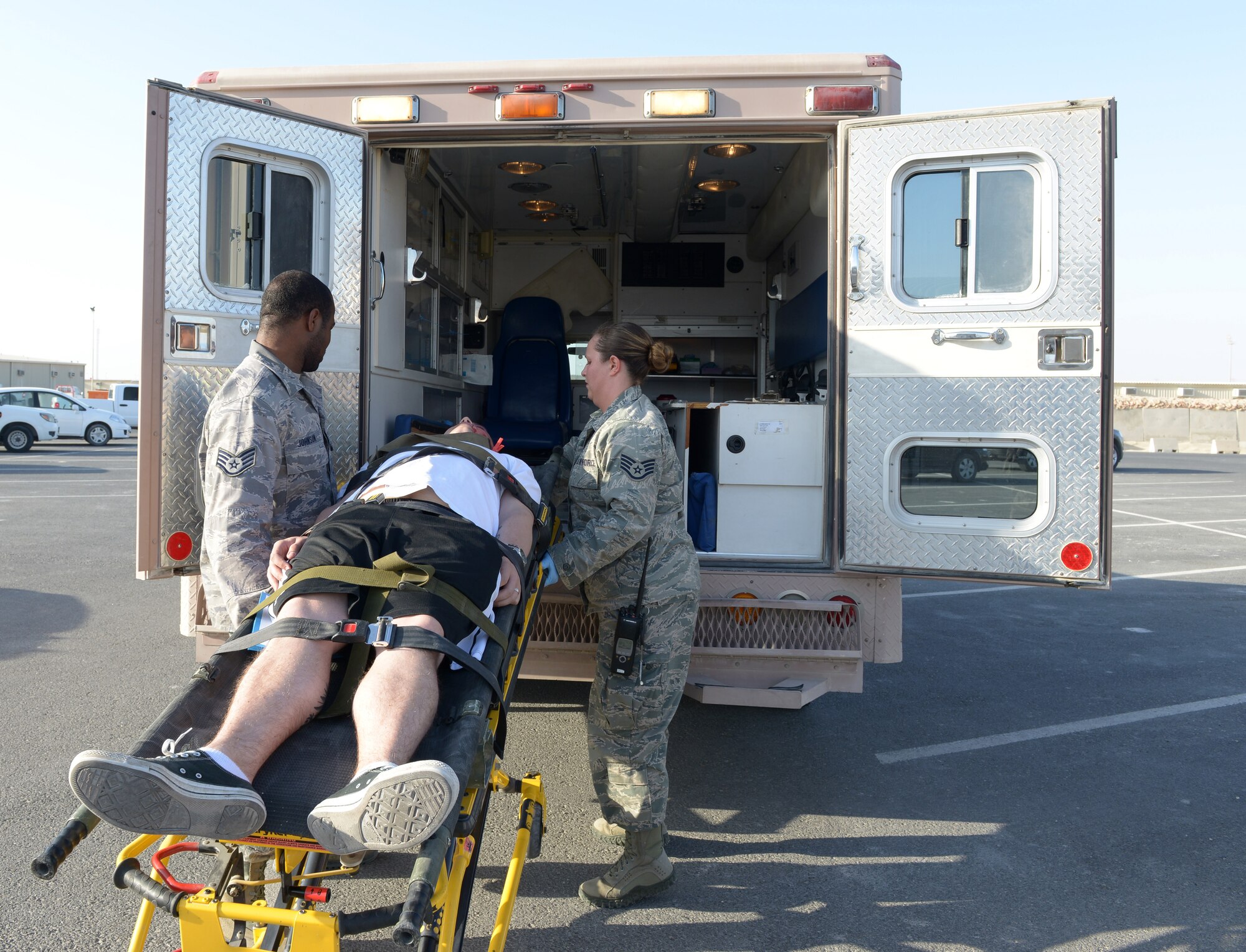 Staff Sgt. Lavarous Johnson and Staff Sgt. Brianna Baker load an injured service member into an ambulance during a mass casualty exercise at Al Udeid Air Base, Qatar, Jan. 31, 2014. Deployed Airmen participate in mass casualty exercises to enhance emergency response skills in response to real world emergencies. Johnson and Baker are 379th Expeditionary Medical Operations Squadron medical technicians. Johnson is deployed from Joint Base Langley- Eustis Air Force Base, Va., and a Miami native. Baker is deployed from Offutt Air Force Base, Neb., and a Rochester, Ill., native.  (U.S. Air Force photo/Senior Airman Hannah Landeros) 